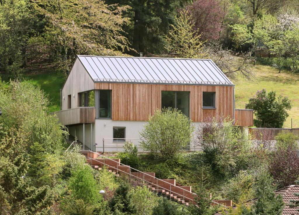 ein Scheunenhaus mit einem Metalldach auf einem Hügel in der Unterkunft Ferienhaus Münzberg in Annweiler am Trifels