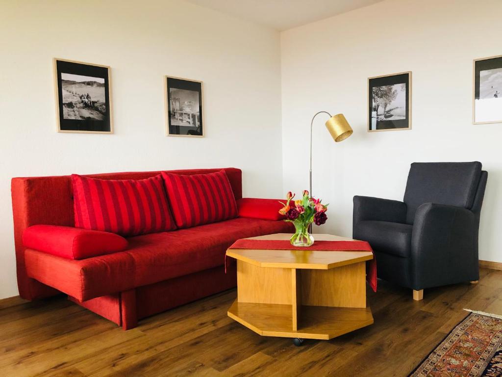 a living room with a red couch and a chair at Ferienhaus Riss in Bolsterlang