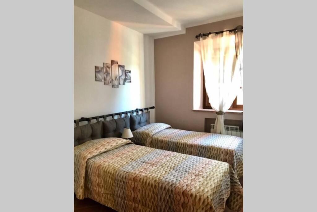 a bedroom with two beds and a window at Agriturismo Il Salicchio app.Benedetta in Pian dʼAlma