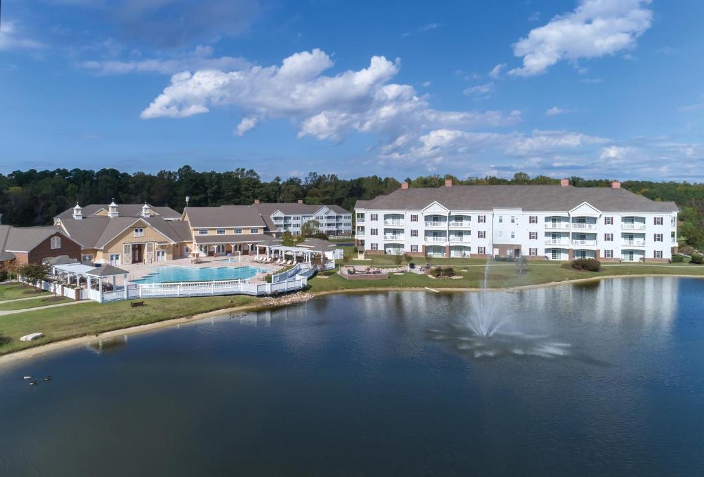 a large apartment complex with a pond in front of it at Club Wyndham Governors Green in Williamsburg