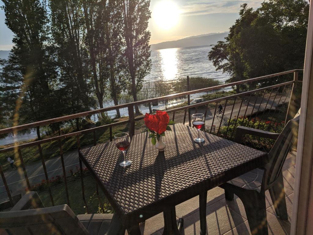 uma mesa com um vaso de flores numa varanda em Ajkoski Apartments Pestani em Ohrid