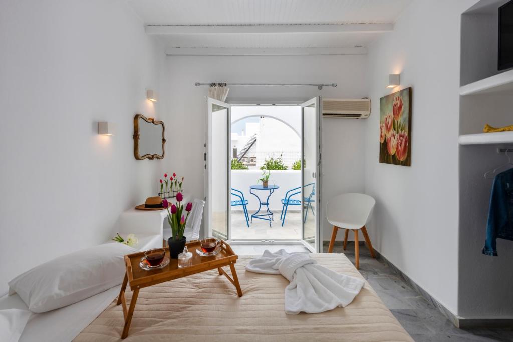 um quarto com uma cama, uma mesa e um pátio em Aegeon Garden em Parikia