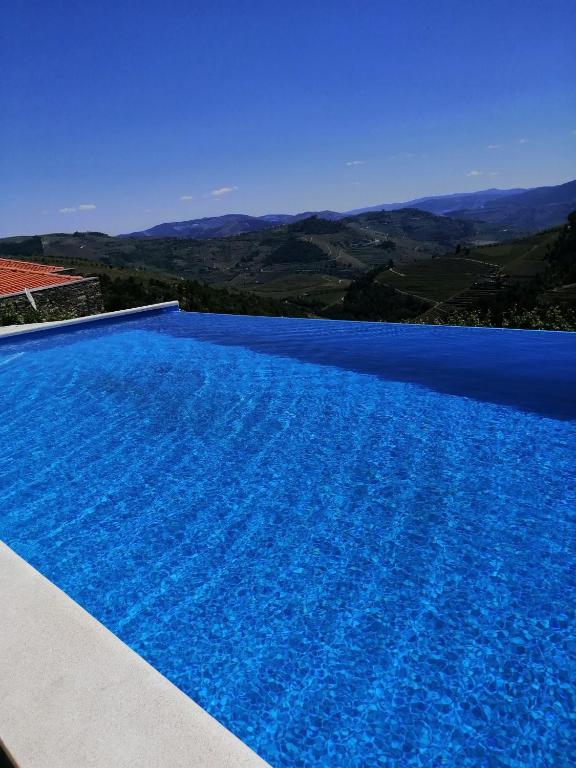 a swimming pool with a view of the water at Quinta Teoria - Teoria Guest House in Sabrosa