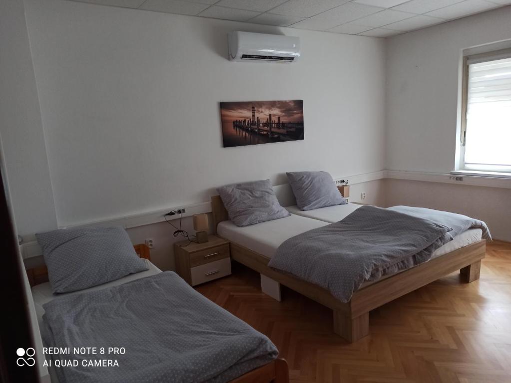 um quarto com duas camas e uma foto na parede em Apartmanový dom Stummerova em Topoľčany