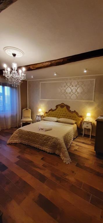 duża sypialnia z dużym łóżkiem i żyrandolem w obiekcie Antica Norma Alloggio Turistico w mieście Norma