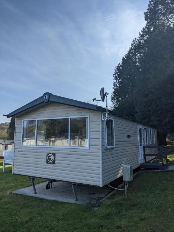 une petite maison est garée dans une cour dans l'établissement 17 Sun Valley Holiday Park, à St Austell