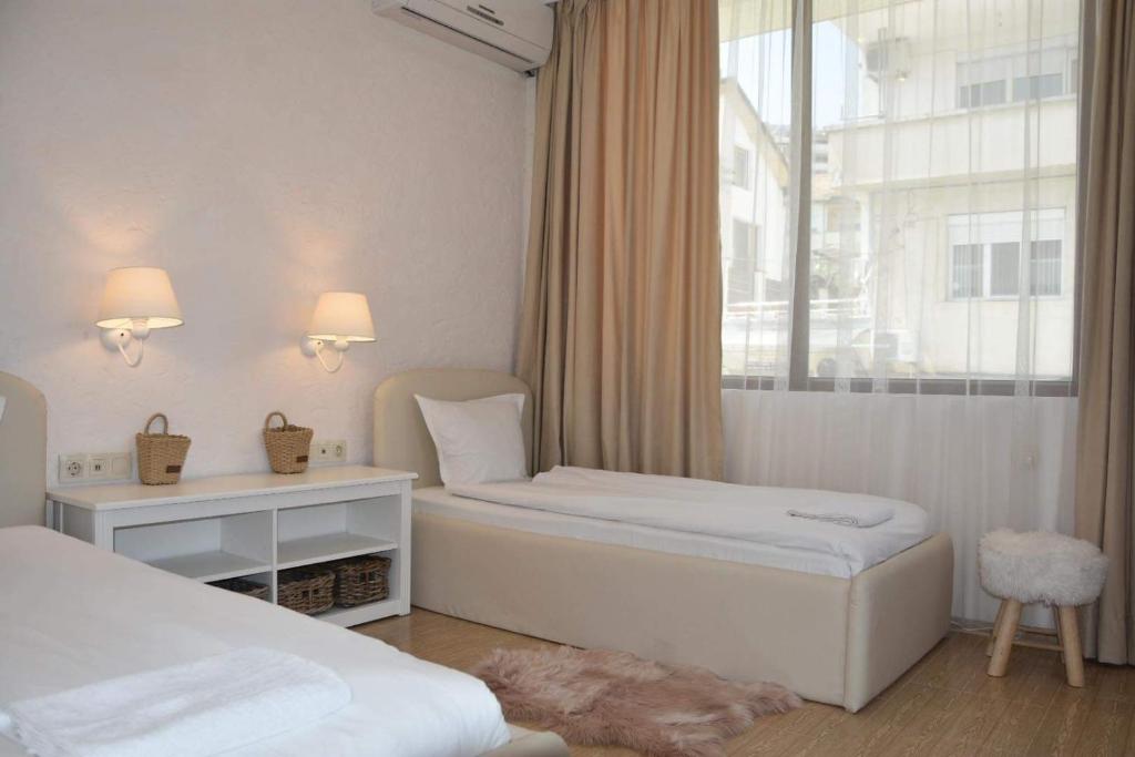 a hotel room with two beds and a window at Princess Apartment in Sandanski