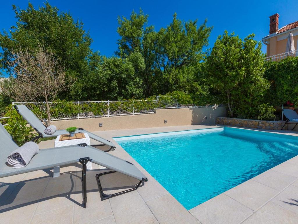 een zwembad met een tafel en een stoel ernaast bij Villa Lara in Jadranovo