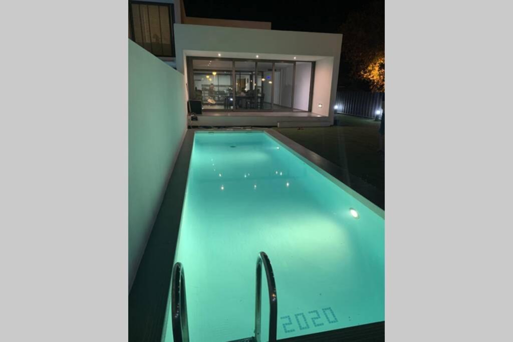 a swimming pool in front of a house at night at Modern Villa With Private Pool/ 400m To The Beach in Grao de Castellón