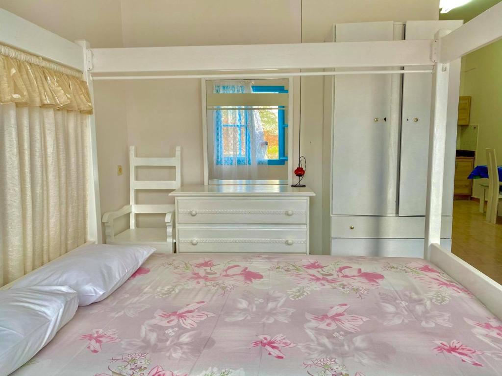 a bedroom with a large bed with a dresser and a window at Sevasti Studios in Panormos Kalymnos