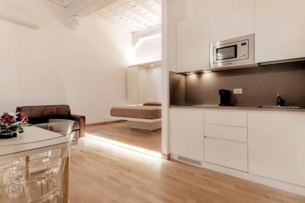 Il comprend une cuisine et un salon avec des placards blancs et un canapé. dans l'établissement NAVONA luxury loft with terrace, à Rome