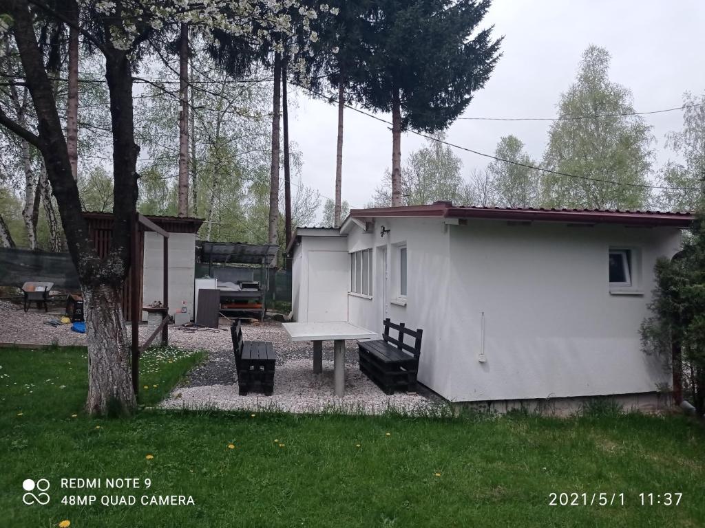 una casa con una mesa de ping pong en un patio en Ravne Apartman, en Visoko