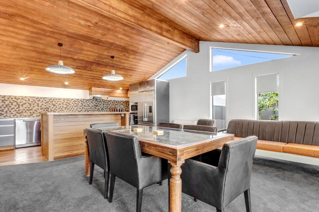 una cucina e una sala da pranzo con soffitto in legno di Modern Charm a Dunedin
