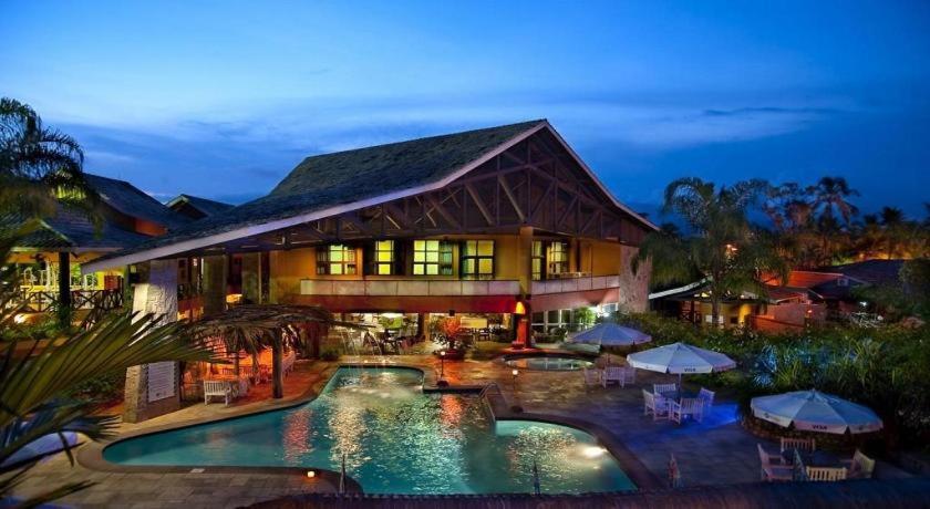 um grande edifício com uma piscina em frente em Ilha Flat Hotel Ap 2202 em Ilhabela