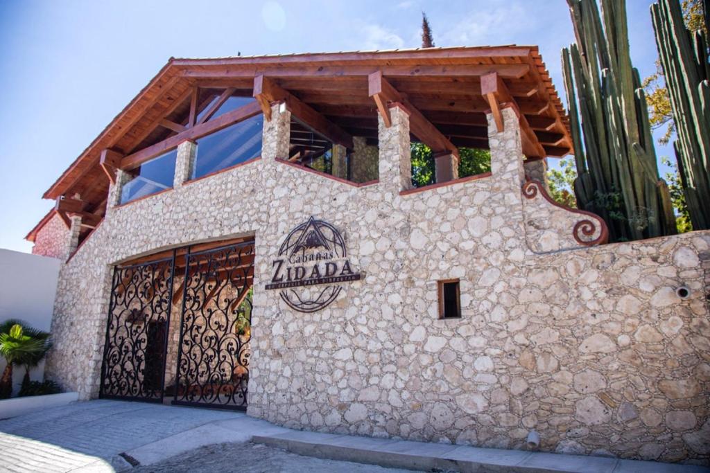 a house with a gate in front of it at Zidada Hotel and Chalets in Bernal