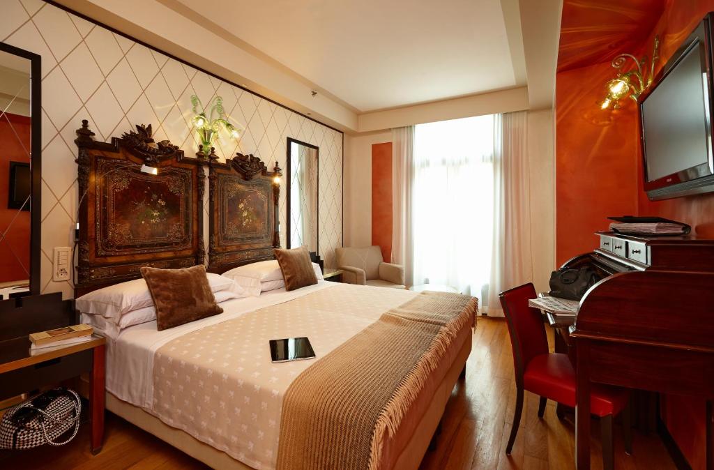 a bedroom with a large bed and a piano at Hotel Saturnia &amp; International in Venice