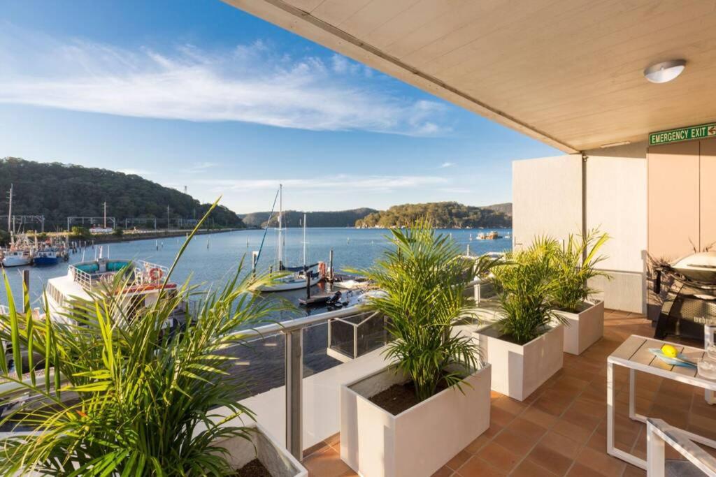 a balcony with plants and a view of a marina at Luxe at Brooklyn - Hawkesbury River Marina in Brooklyn