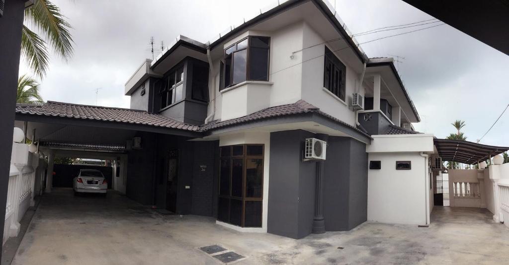 a white and black house with a car garage at Homestay Muar in Muar