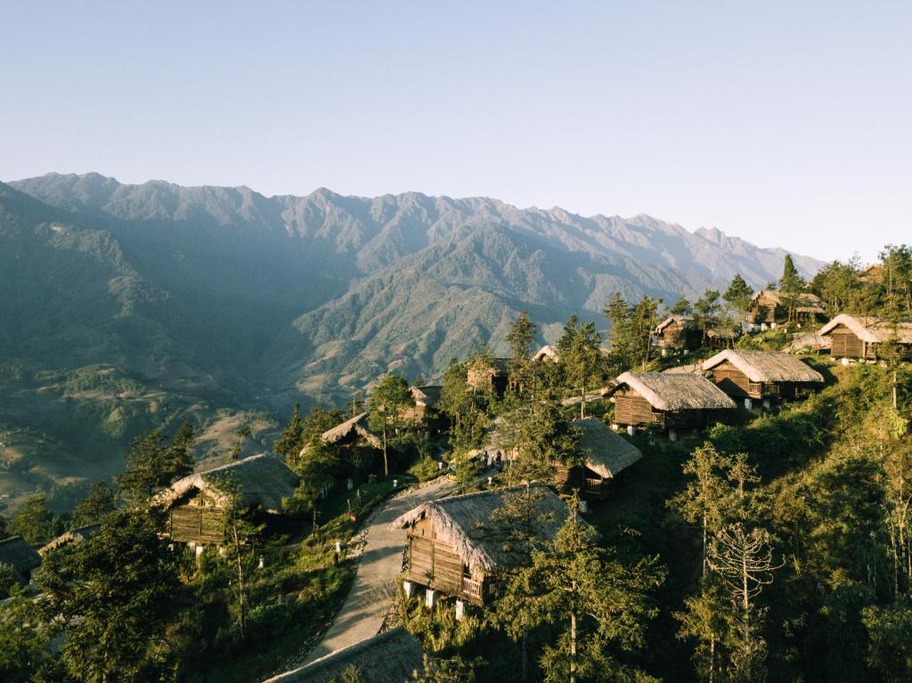 uma aldeia numa colina com montanhas ao fundo em Sapa Jade Hill Resort & Spa em Sa Pa