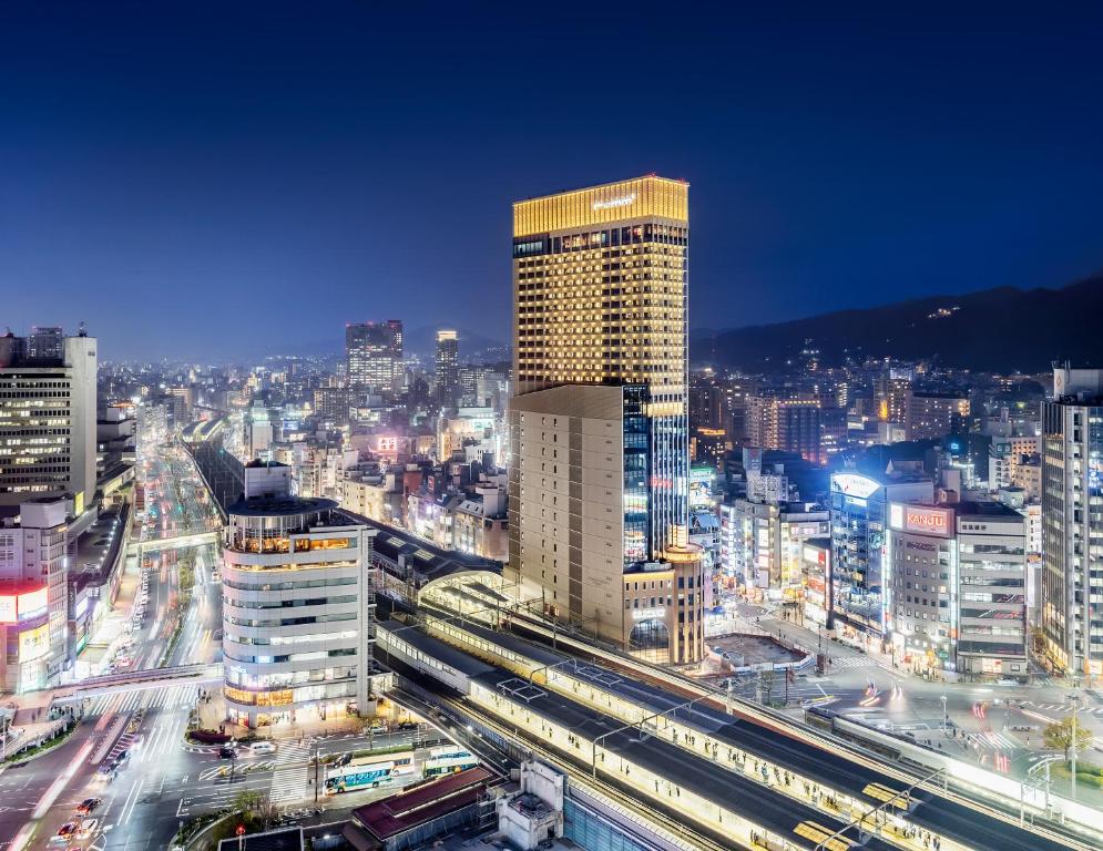 Blick auf eine Stadt in der Nacht mit Zügen in der Unterkunft remm plus Kobe Sannomiya in Kōbe