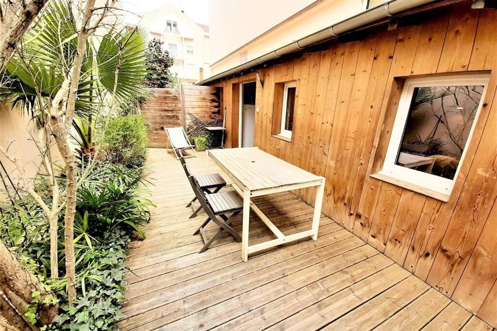 eine Holzterrasse mit einem Tisch und 2 Stühlen in der Unterkunft 6 personnes, 2 studios indépendants avec terrasse. in Arcachon