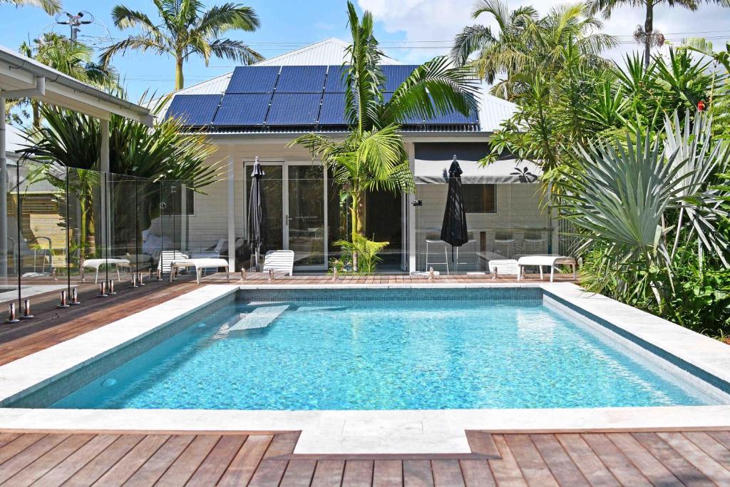 a swimming pool in the backyard of a house at Byron Palms Guesthouse & Spa - Adults Only in Byron Bay