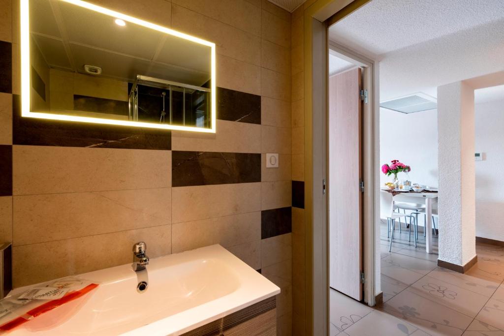 um banheiro com uma pia e um espelho em Appart'hotel le Pèlerin em Lourdes
