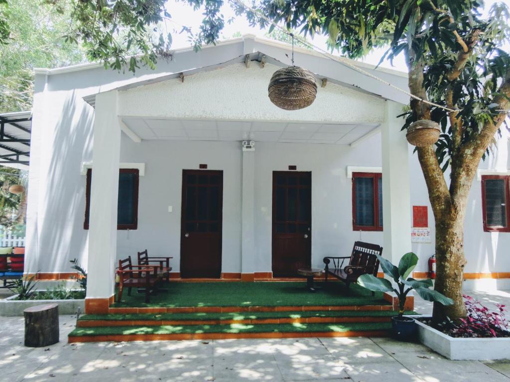 a white house with a tree in front of it at Eden House & Coffee Con Dao in Con Dao