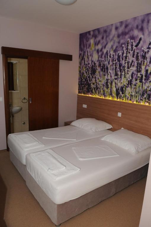 a bedroom with a large bed with a painting on the wall at Guest House Ostojić in Međugorje
