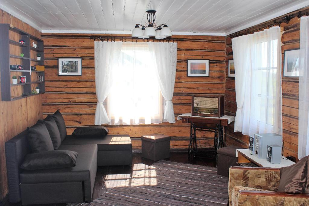 a living room with a couch and a window at Lauku māja Latgalē - ''Siguldas'' 