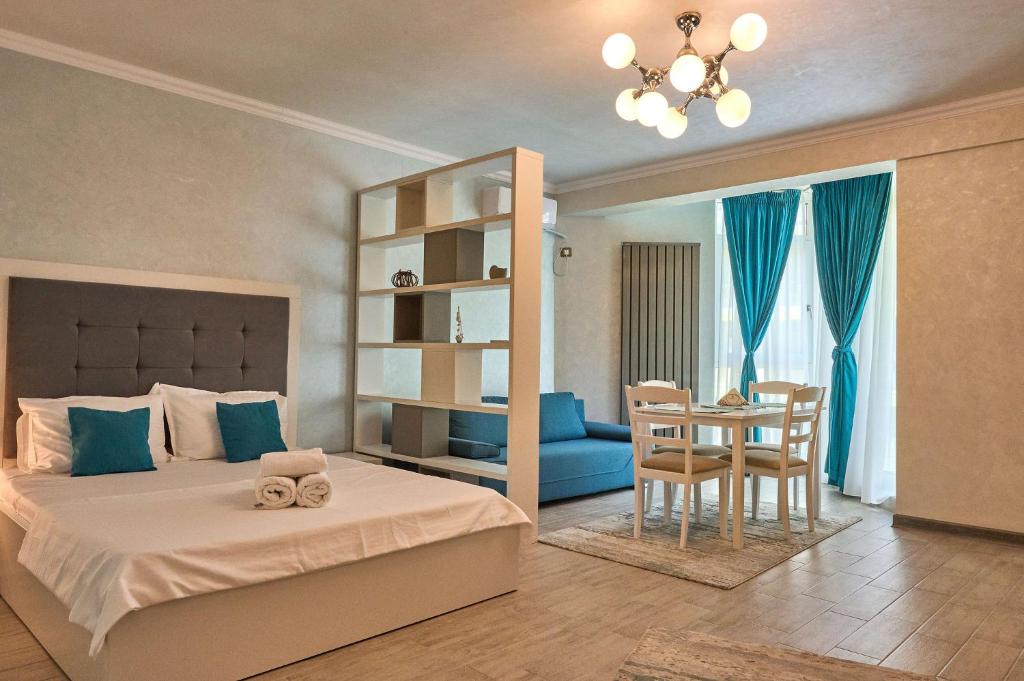 een slaapkamer met een bed en een tafel en stoelen bij Moonlight Studio - Spa n Pools beach Resort in Mamaia