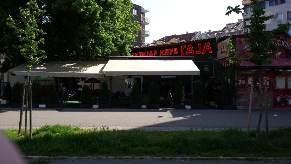 un edificio con un toldo blanco en la calle en Guest House Gaja, en Novi Sad