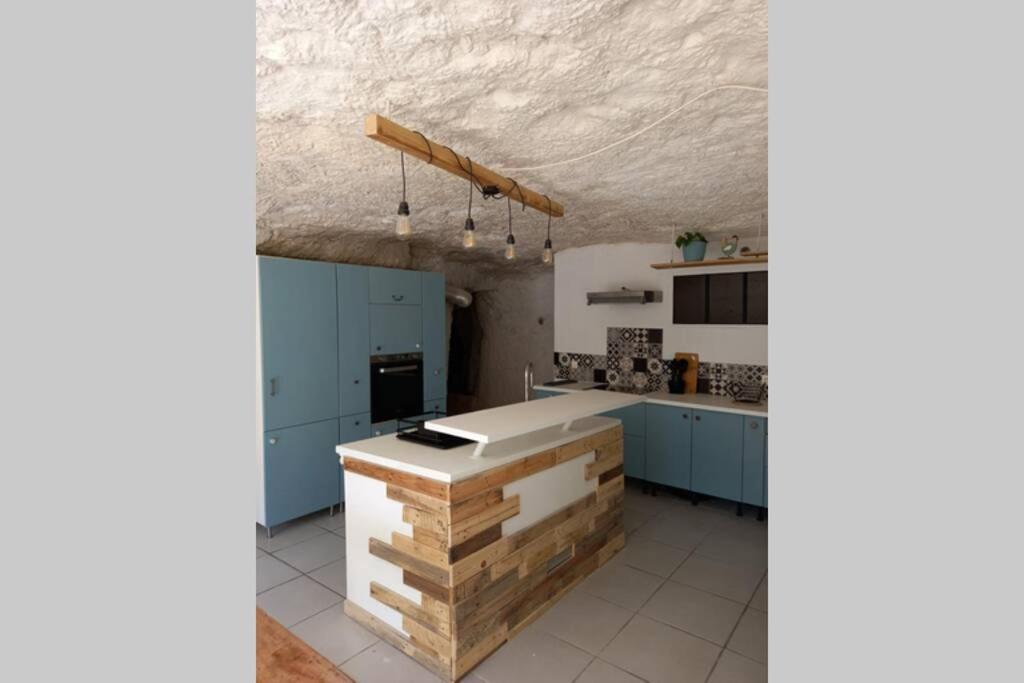 une cuisine avec des placards bleus et un comptoir blanc dans l'établissement La Trog'Laudy gîte 4 étoiles au coeur des vignes, à Vouvray
