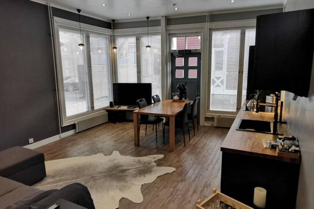 a living room with a table and chairs and windows at Luxury apartment In the middle Of old Rauma in Rauma