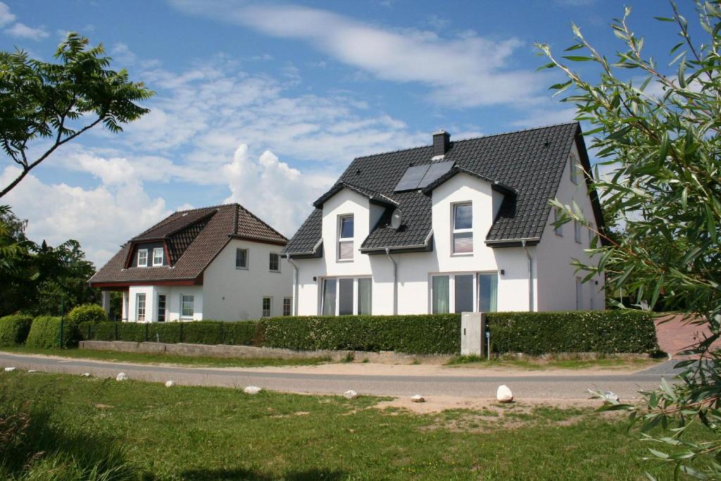 ein weißes Haus mit schwarzem Dach in der Unterkunft F-1037 Haus Neuendorf - Kaminfeuer in Putbus
