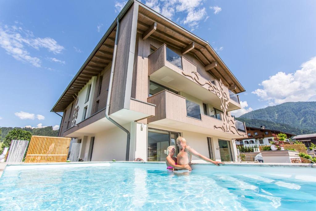 a woman in a swimming pool in front of a house at Enjoy The Alps in Flachau