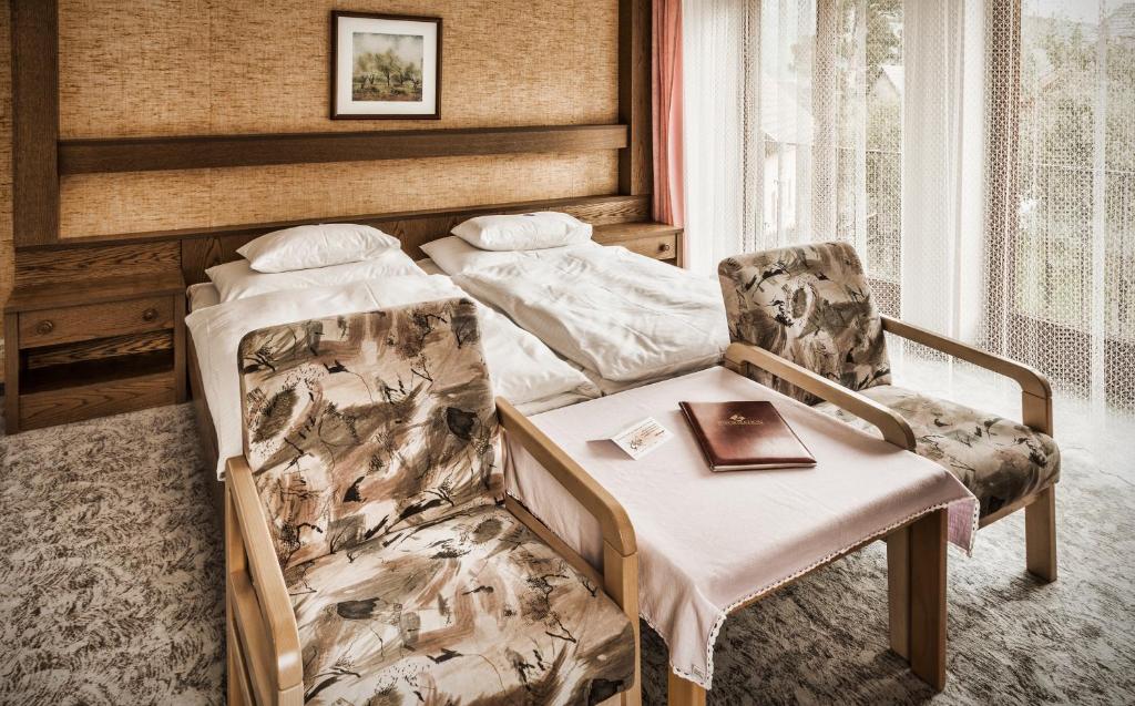 a bedroom with a bed and a chair and a book at schaus Lüftenegger Ferienhaus in Mauterndorf
