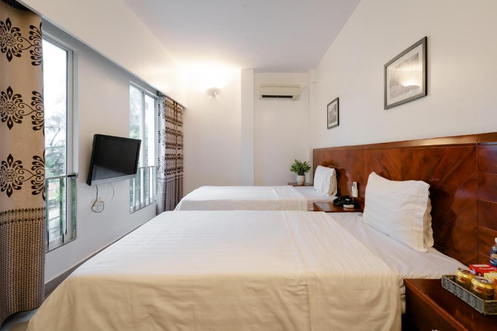 een hotelkamer met 2 bedden en een televisie bij White Palace 2 in Thái Bình
