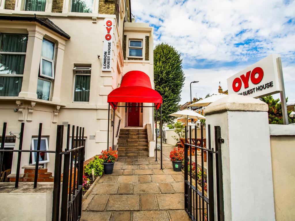 
a red and white fire hydrant on the side of a building at OYO London Guest House in London
