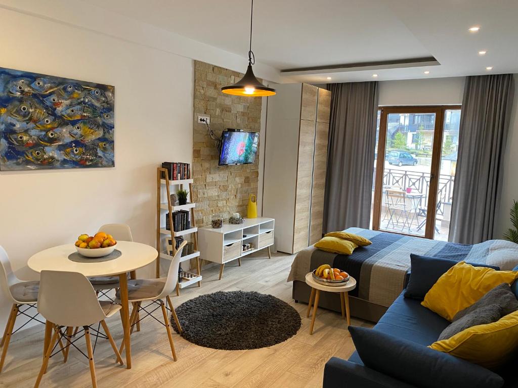 a living room with a couch and a table at Milmari Resort - Apartman L43 in Kopaonik
