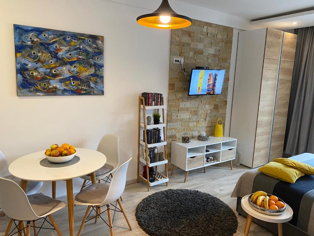 a living room with a table and a dining room at Milmari Resort - Apartman L43 in Kopaonik