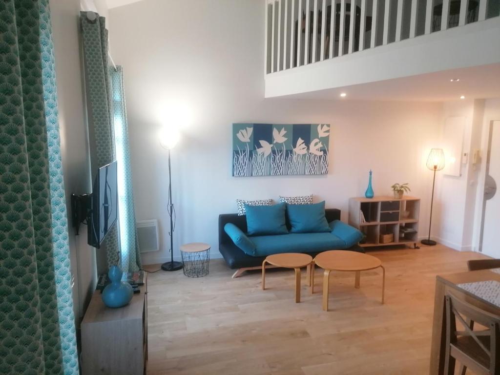 モンペリエにあるMontpellier centre Duplex style loftのリビングルーム(青いソファ、テーブル2台付)