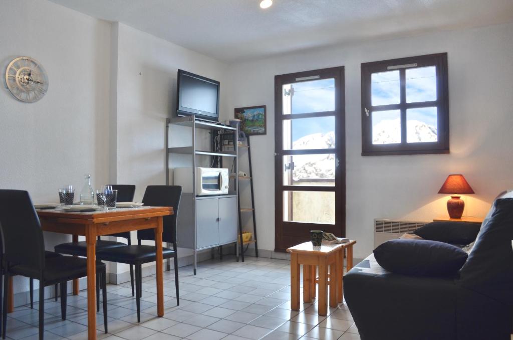 a living room with a table and a dining room at Granges 9 - Appartement vue époustouflante, au pied des pistes Domaine Alpe d'Huez in Villard-Reculas