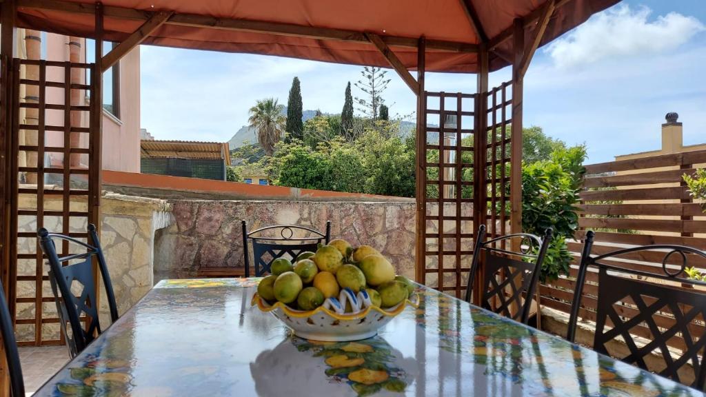 a bowl of fruit on a table on a patio at B&B Verdeblu in Valderice