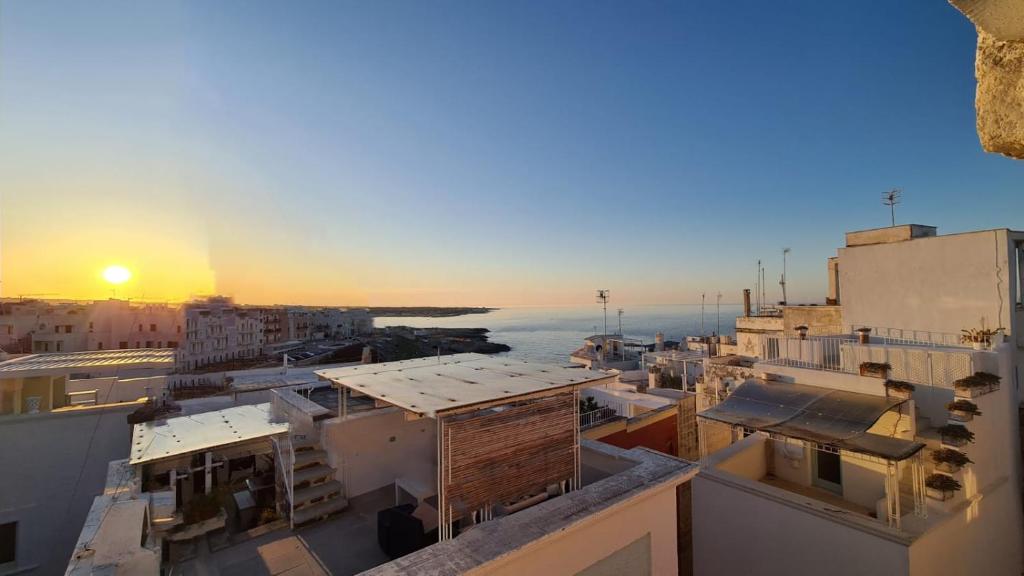 vista su una città con edifici e tramonto di FONTEblu B&B a Polignano a Mare