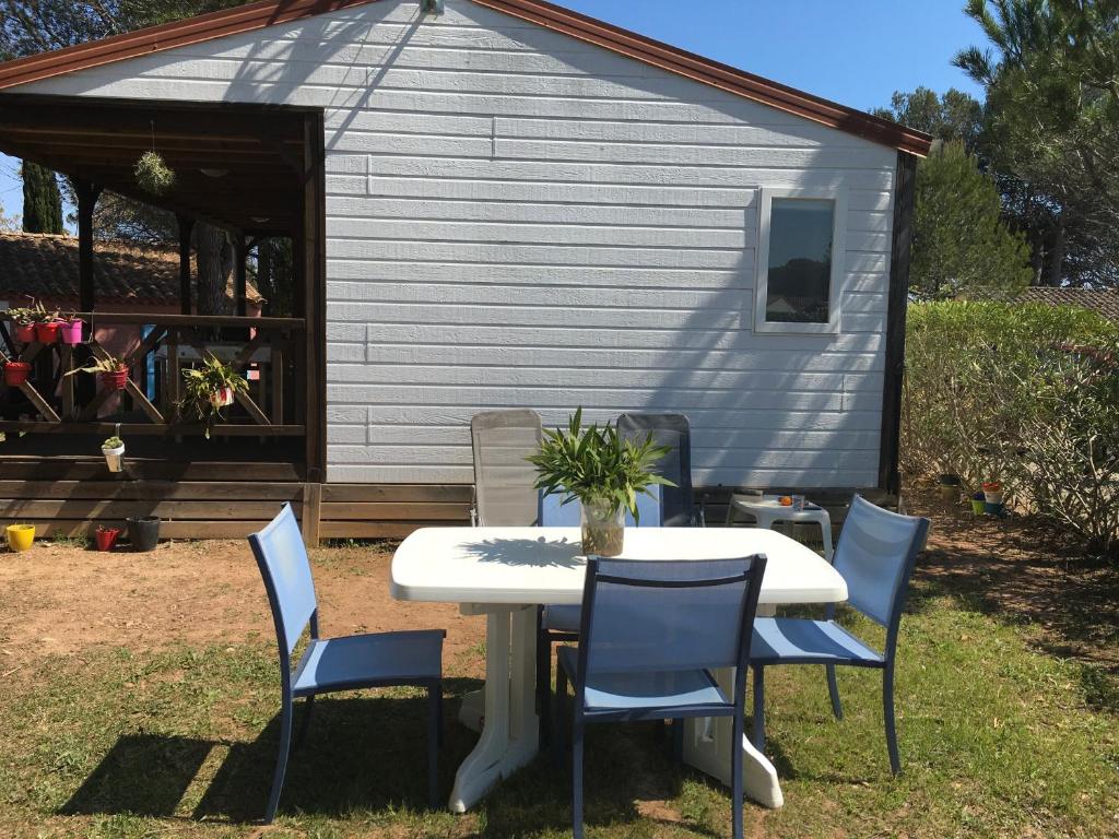 a table and chairs in front of a shed at Oasis village in Puget-sur-Argens