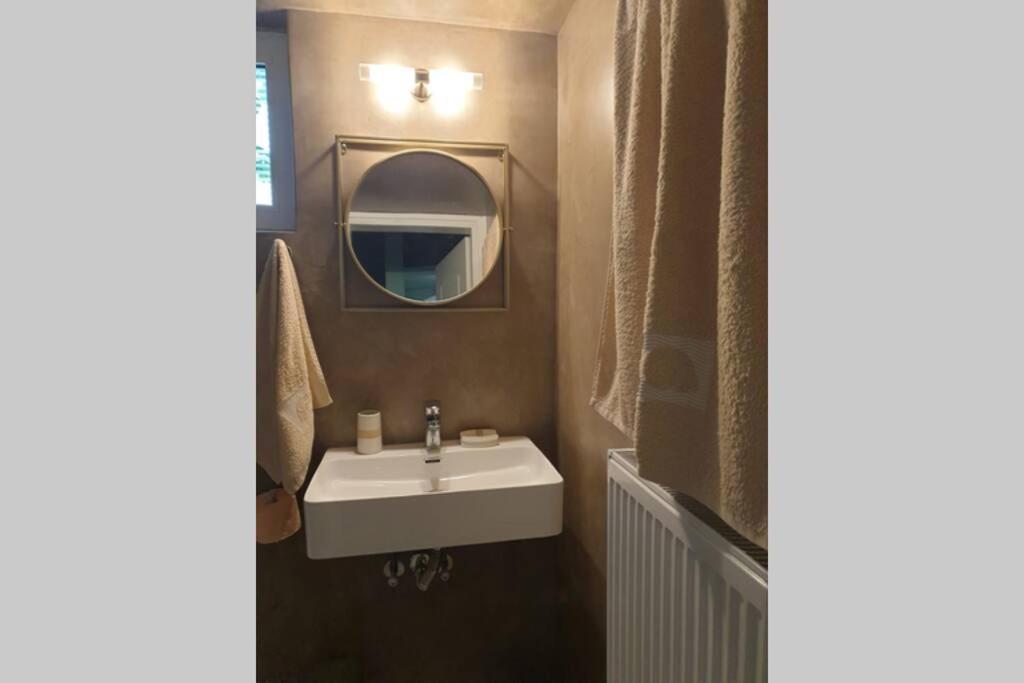 a bathroom with a sink and a mirror at central studio very close to the port of Volos in Volos