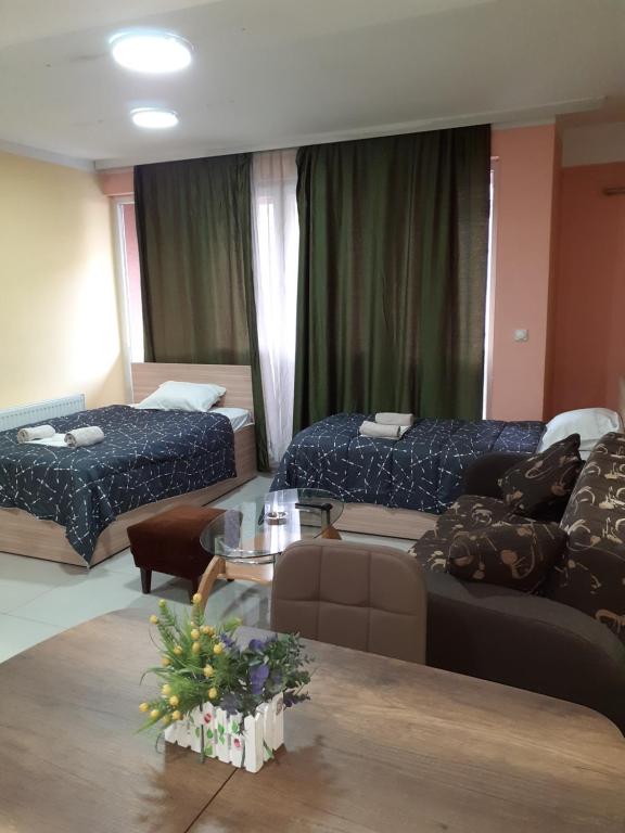 Habitación de hotel con 2 camas y sofá en Laki Apartments & Suites, en Skopje