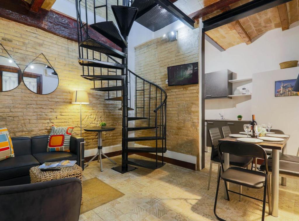 a living room with a spiral staircase in a brick wall at New Listing DUPLEX NEAR THE BEACH Barceloneta in Barcelona