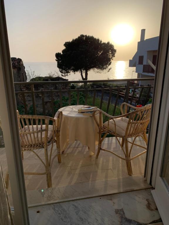 un tavolo e sedie su un balcone con vista sull'oceano di Il Mandarino Rooms & Apartments a Cittadella del Capo